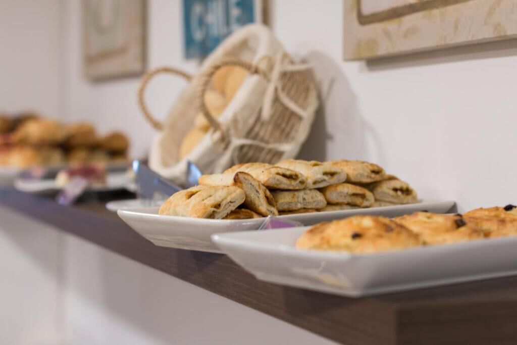 Una mesa de buffet con diversos productos de panadería, incluyendo pasteles y pan.