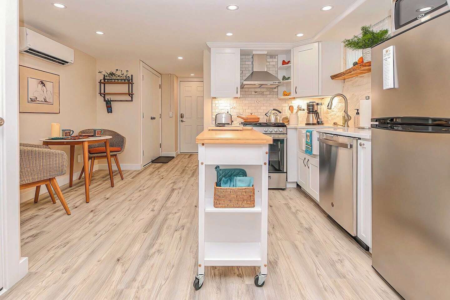 A modern kitchen with white cabinetry, a wooden countertop, and a built-in oven.