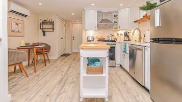 A modern kitchen with white cabinetry, a wooden countertop, and a built-in oven.