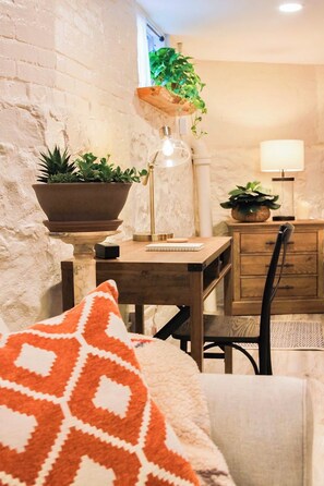 A cozy room with a wooden desk, a chair, a lamp, and a potted plant. - Enjoy a comfortable stay in New Haven, perfectly located near Yale and the city’s top attractions. This cozy home offers a peaceful neighborhood setting while keeping you just minutes from downtown dining, shopping, and cultural spots. (New Haven)