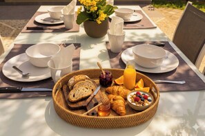 A breakfast setup with bread, croissants, berries, honey, and orange juice on a table. - Cozy house with pool in Álora, Málaga (Alora)