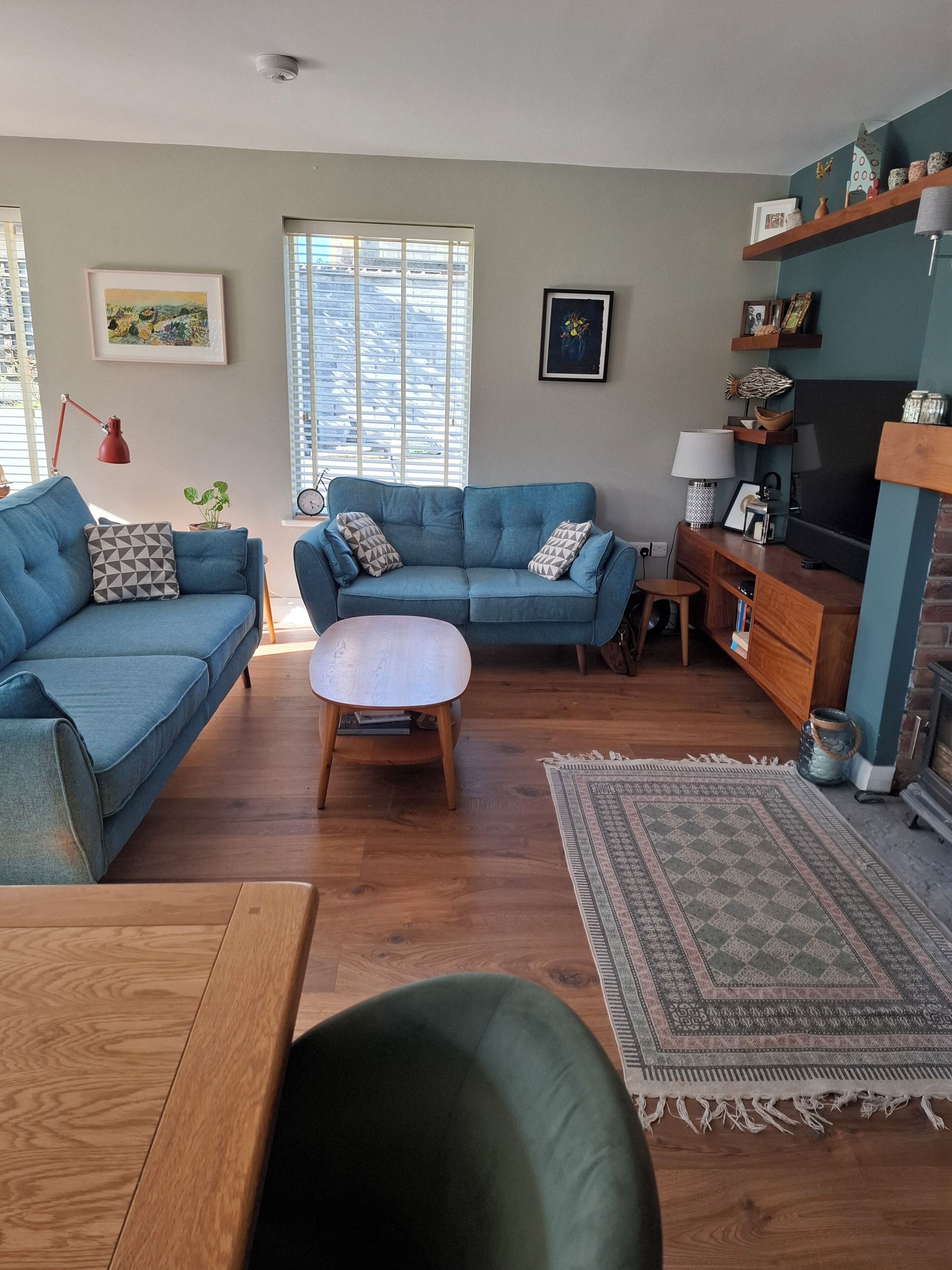A living room with two sofas, a coffee table, a TV stand, and a fireplace.