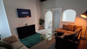 A living room with a television, sofas, a coffee table, and a window. - Alice Place (Sunderland)