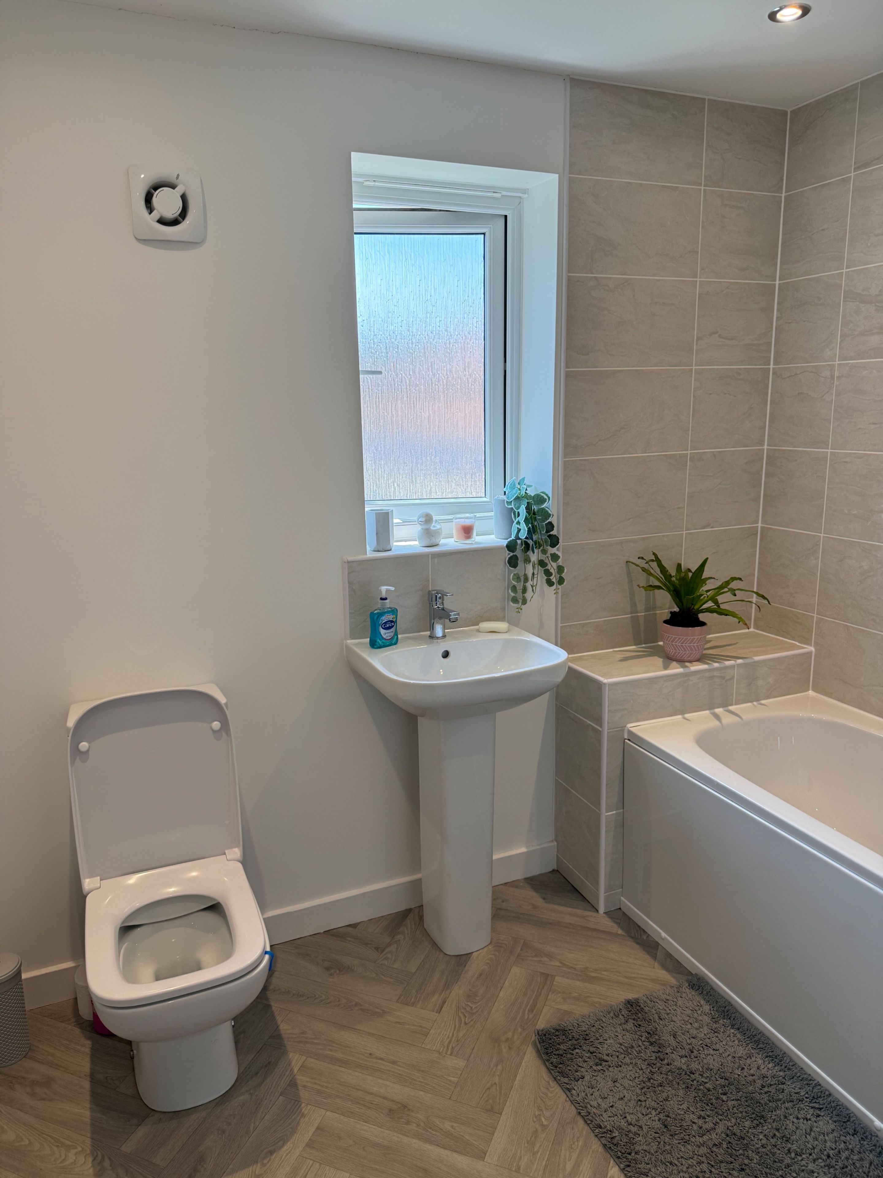Une salle de bain avec des toilettes, un lavabo et une baignoire.