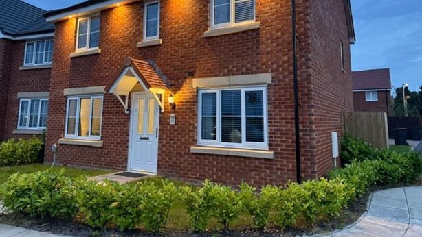 A two-story brick house with a front porch, multiple windows, and a well-maintained garden. - House Sleeps 6 With Parking and Garden (Liverpool)