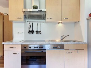 Eine moderne Küche mit Edelstahlgeräten, Holzschränken und einem eingebauten Backofen.
