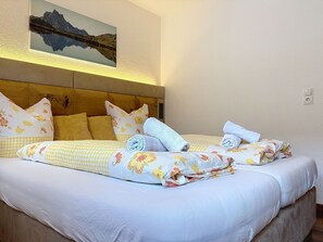 A double bed with floral bedding, multiple pillows, and a headboard. - Lovely apartment for 5 guests with WIFI and TV (Pettneu)