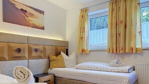 Ein Hotelzimmer mit einem Bett, einem Nachttisch, einer Wanduhr und einem Fenster mit Vorhängen.