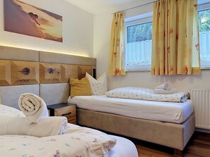 Ein Hotelzimmer mit einem Bett, einem Nachttisch, einer Wanduhr und einem Fenster mit Vorhängen.