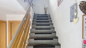 Eine Treppe mit Handlauf, Holzboden und einer an der Wand befestigten Plakette.