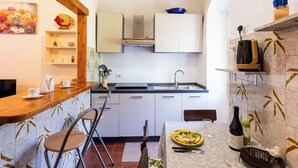 Una cucina compatta con un bancone in legno, un tavolo da pranzo con sedie e un'isola con lavandino.