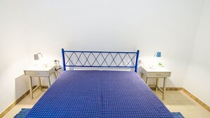 Une chambre avec un lit, deux tables de chevet et un bureau.