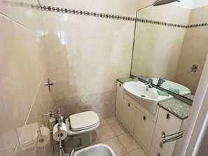 Ein Badezimmer mit Toilette, Waschbecken und Dusche.