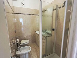 A bathroom with a toilet, bidet, and glass-enclosed shower stall. - Nice apartment for 4 guests with A/C, WIFI, TV and patio (Rapallo)