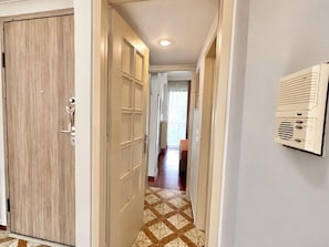 A hallway with a wooden door, a radiator, and a tiled floor. - Stylish Stay for 3 - Haidari, Athens by ΜΡS (Chaidari)