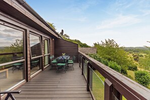 A wooden deck with a table and chairs, overlooking a landscape. - Host & Stay | Hornbeam Lodge (Grantham)