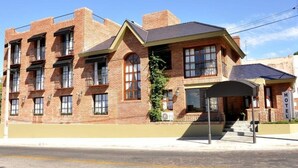 A two-story brick building with a flat roof, multiple windows, and a covered entrance.