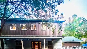 A two-story house with a porch, a front door, and a small front yard. - River Retreat (Valliant)