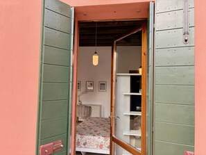 A room with a bed, a radiator, and a shelf with items.