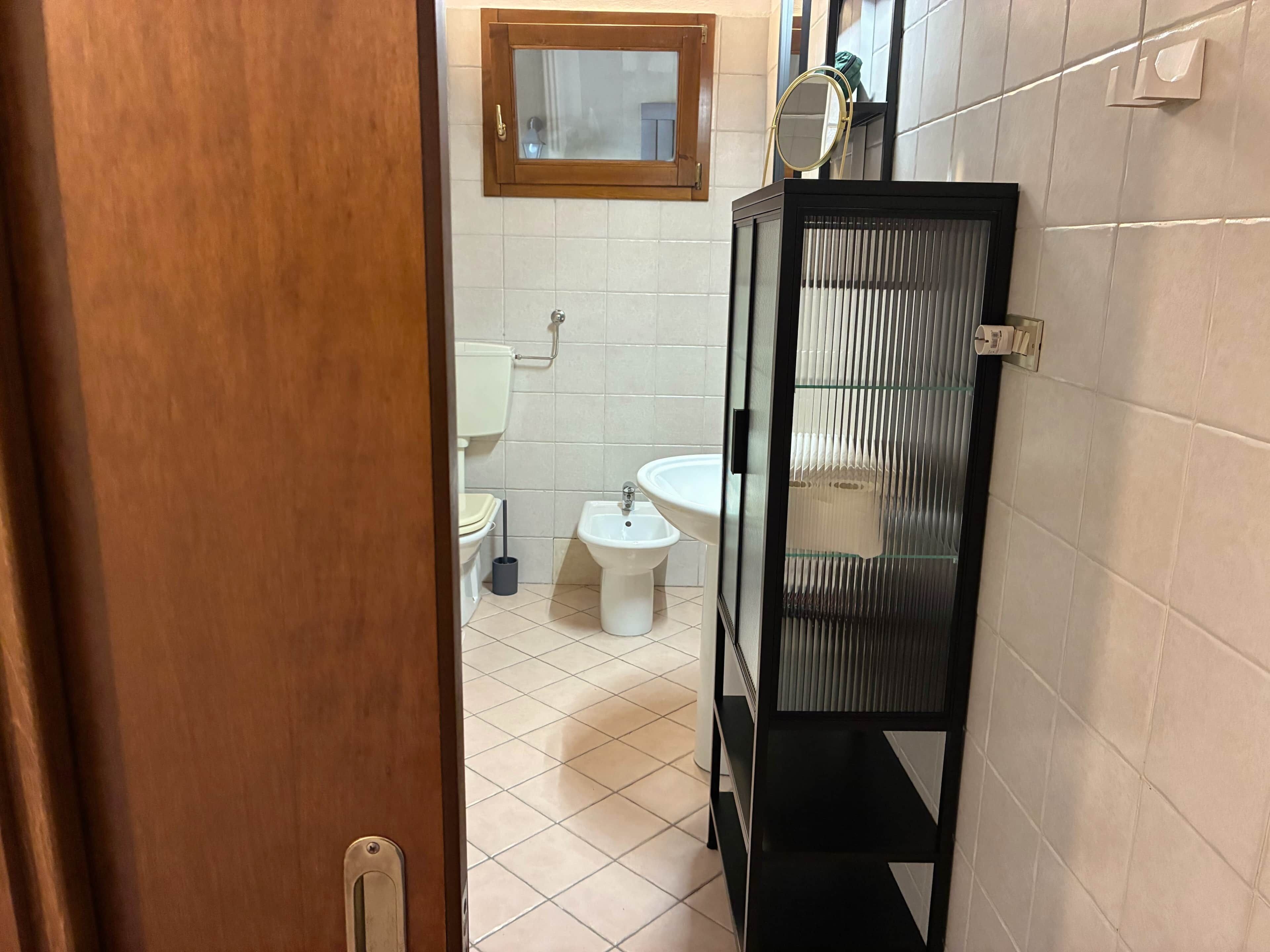 Une salle de bain équipée de toilettes, d’un bidet et d’un lavabo.
