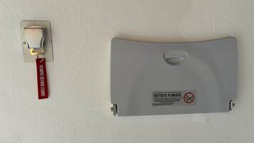 A wall-mounted light switch and a fire safety sign.