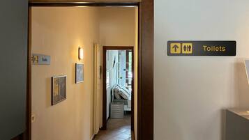A hotel hallway with a sign indicating the direction to the toilets.