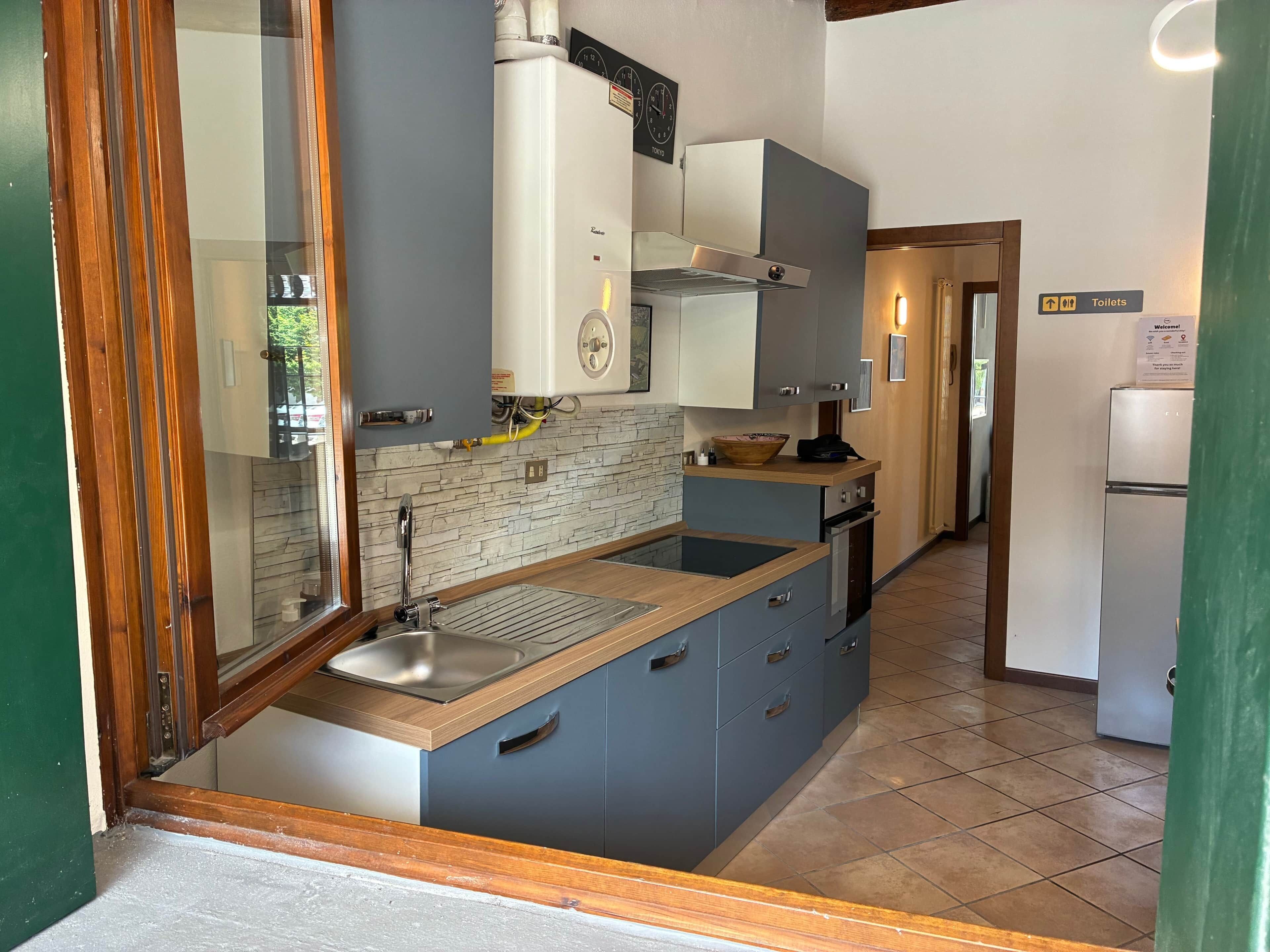 A modern kitchen with a built-in stove, a sink, and a wooden countertop.