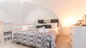 Un dormitorio con cama, mesita de noche, cómoda y ventana.
