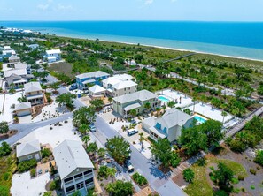 Un área residencial costera con varias casas, una playa y un muelle.