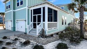 A two-story house with a covered porch, a garage, and a number 401 sign. - Arlanymor (Port St. Joe)