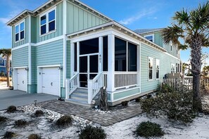 A two-story house with a covered porch, a garage, and a number 401 sign. - Arlanymor (Port St. Joe)