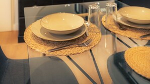 A dining table set with plates, cutlery, and salt and pepper shakers, with a mirror above and a dark-colored cabinet below. - Stunning Apartment in Old Cognac, Close to All Amenities (Cognac)
