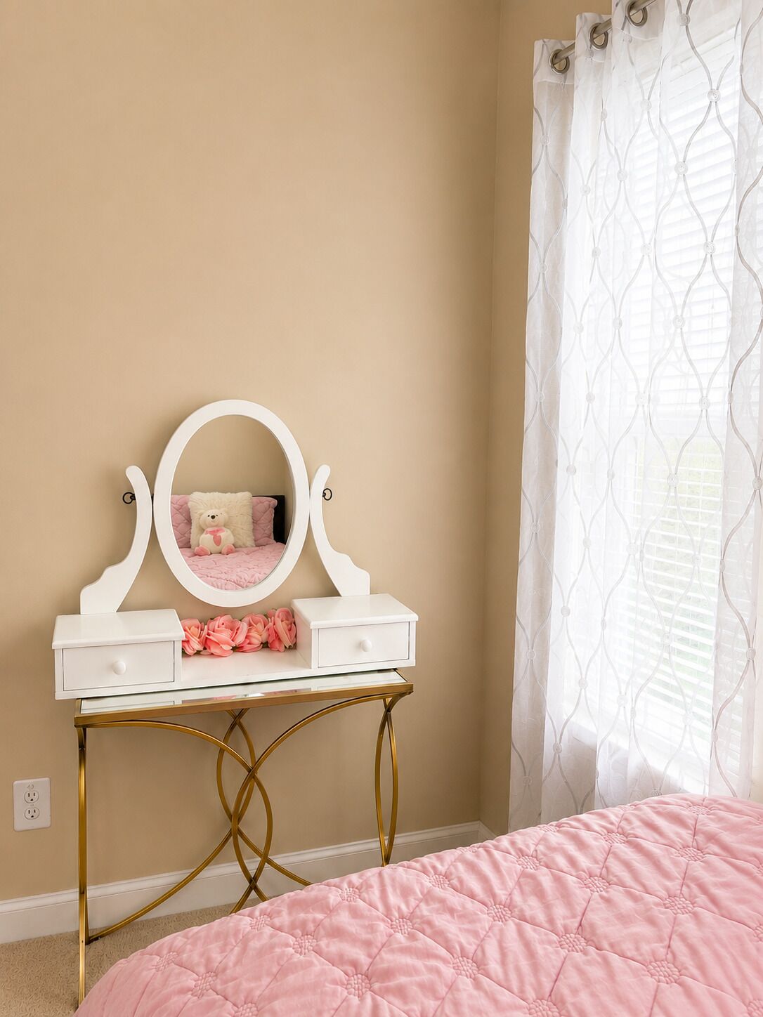 A bedroom with a vanity, a bed, and a window with curtains.
