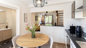 Una cocina moderna con una mesa redonda de comedor, una cafetera y un hervidor.