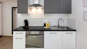 Eine moderne Küche mit integrierter Kaffeemaschine, Spüle und Geschirrspüler.