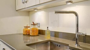 A kitchen with a stainless steel sink, two jars of pasta, and a bottle of dish soap. - HS1 - Stylish 3-Bed near Kensington High Street (Greater London)