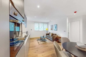 Un espace de vie moderne comprenant une cuisine, un coin repas et un espace détente.