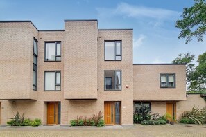 A multi-story building with a brick facade, multiple windows, and doors. - VW5 - Luxury 3 Bed Townhouse with Parking (Greater London)