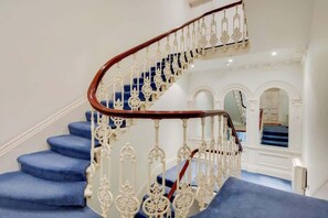 Eine Wendeltreppe mit blau befliessten Stufen und aufwendigen weißen Geländern.