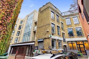 A multi-story building with a brick facade, large windows, and a flat roof. - BR9 - Elegant 2-Bed near Borough Market (Greater London)