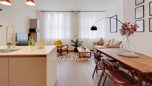 Ein moderner Wohnraum mit Küche, Essbereich und Sitzgelegenheiten.