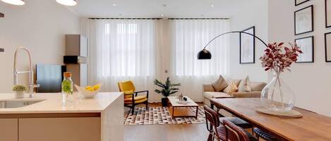 A modern living space with a kitchen, dining area, and seating.