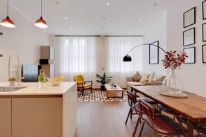 Ein moderner Wohnraum mit Küche, Essbereich und Sitzgelegenheiten.
