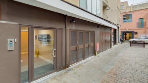 Un bâtiment avec une entrée au rez-de-chaussée, un système d’alarme incendie et une fenêtre bien visible.