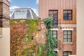 A building with a brick facade, a window with a metal railing, and a clear sky. - BR13 - Elegant 1-Bed near London Bridge (Greater London)
