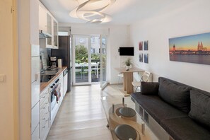Un apartament modern amb cuina, zona de menjador i saló.