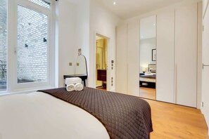 A bedroom with a bed, a window, a mirror, and a wardrobe. - BR8 - Spacious 2-Bed Apartment Near Borough Market (Greater London)