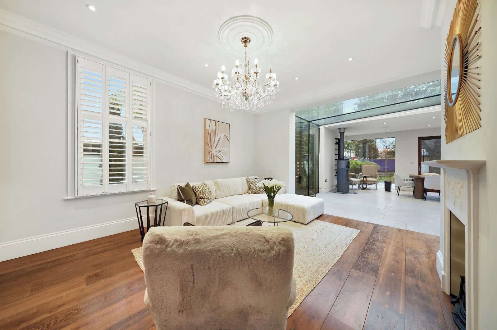 A spacious living room with a white sofa, a round coffee table, and a fireplace.