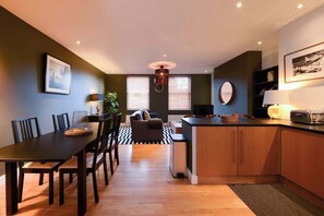 Una cocina moderna con comedor, armarios de madera y una isla central.