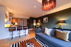 Ein modernes Wohnzimmer mit Sofa, Couchtisch und Barhocker.